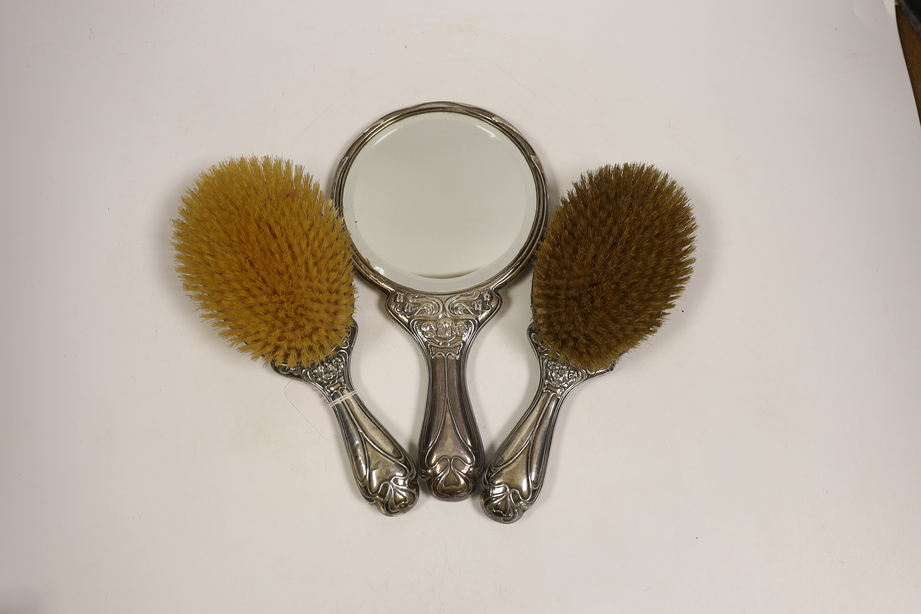 An Edwardian Art Nouveau silver mounted hand mirror and hair brush, maker Charles Horner?, Birmingham, 1906/7 and a similar hair brush, W.G. Keight & Co, Birmingham, 1905.